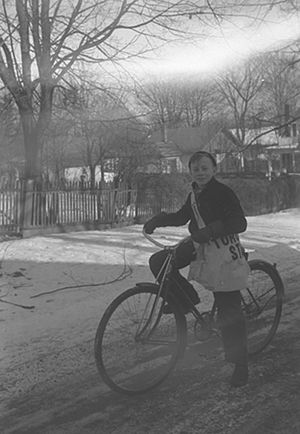 English: A boy on a bicycle with a Toronto Sta...